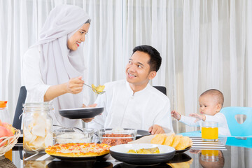 Muslim woman serve foods to husband and daughter