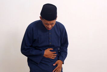 Fototapeta na wymiar Portrait of asian muslim man having stomachache. Isolated on white background