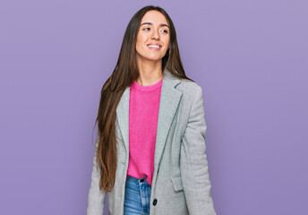 Fototapeta premium Young hispanic girl wearing business clothes looking away to side with smile on face, natural expression. laughing confident.