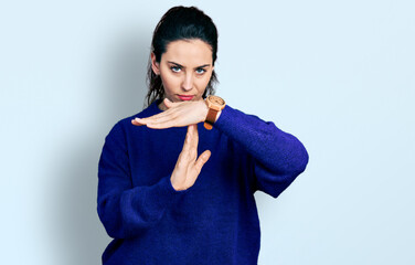 Young hispanic woman wearing casual clothes doing time out gesture with hands, frustrated and...