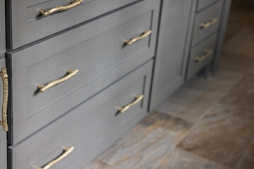 Gray kitchen cabinets with modern gold drawer pulls in a recently renovated kitchen