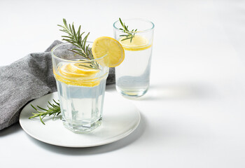Glasses with fresh lemon water or homemade lemonade with rosemary