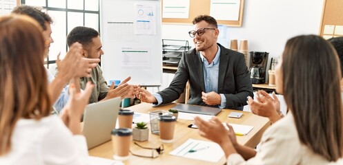 Group of business workers smiling and clapping to partner at the office.