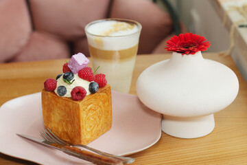cube formed dessert with cream, raspberry, blueberry and marshmallow topping closeup photo