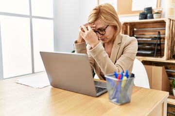 Middle age blonde woman working with serious expression at office