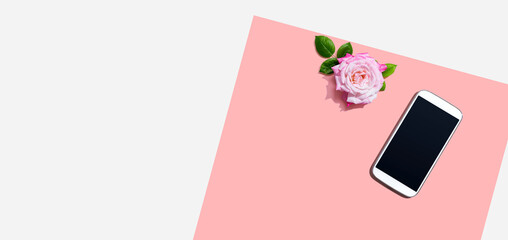 Smartphone with a pink rose - flat lay