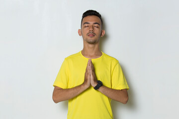 Young handsome sport man doing yoga relaxing meditating on white background
