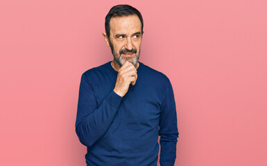 Middle age hispanic man wearing casual clothes with hand on chin thinking about question, pensive expression. smiling with thoughtful face. doubt concept.