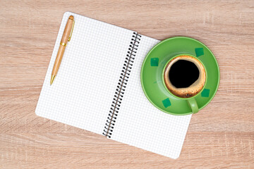 Coffee cup, spiral notebook and pen on the wooden table