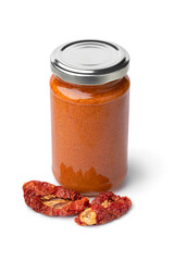 Glass jar with red Italian pesto and dried sweet tomatoes in front  isolated on white background 