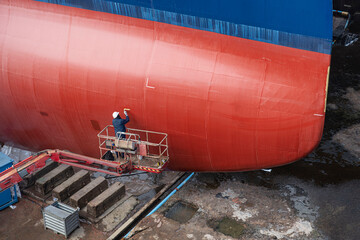 Close-up of a man renovating a ship in a dry dock in the port of Saint Nazaire in France