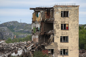 Fototapeta na wymiar Russia, Gadzhievo - August 14, 2021: demolition of residential buildings with construction equipment