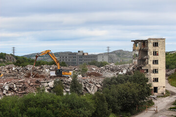 Russia, Gadzhievo - August 14, 2021: demolition of residential buildings with construction equipment