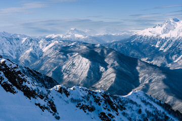 Fototapeta na wymiar Winter mountain landscape. Caucasus ridge covered with snow in sunny day. Scenic mountain landscape with white-snow peaks .