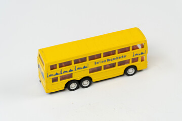 Fototapeta na wymiar Miniature yellow double decker metal bus isolated on white background, tourist big bus mini toy front view, slanted angle object