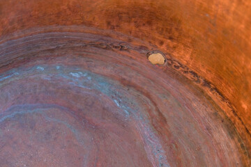 Old copper kitchen utensil. Soldering on a copper surface. Oxidized copper.