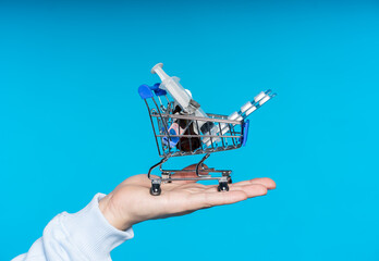 on hand is a trolley with medicines. close-up. blue background