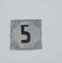 PLACA DEL NUMERO 5 EN UNA PARED BLANCA