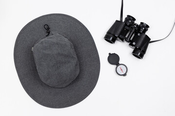Hat, binoculars, and compass isolated in a flat layout design on a pure white background
