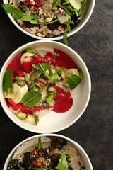 Vegan food. Breakfast oatmeal porridge with banana, strawberry sauce, pumpkin seeds and mint on a dark background in an eco paper box. Healthy balanced food. Top view, overhead, banner