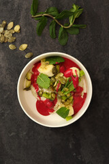 Vegan food. Breakfast oatmeal porridge with banana, strawberry sauce, pumpkin seeds and mint on a dark background in an eco paper box. Healthy balanced food. Top view, overhead, banner
