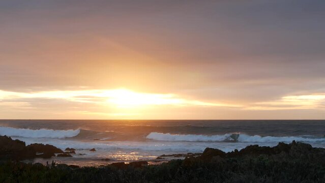 Rocky craggy pacific ocean coast, sea water waves crashing, 17-mile drive, Monterey California USA. Dramatic sunset sky nature near Point Lobos, Big Sur and Pebble beach. Seamless looped cinemagraph.