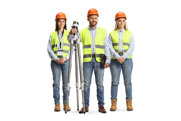 Team of young geodetic surveyors posing with a measuring equipment