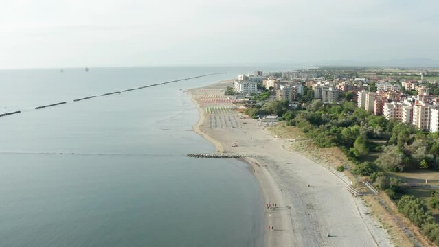 Aerial shot of sandy beach with umbrellas and adriatic sea, typical Emilia Romagna shore.Summer vacation concept.Lido Adriano town,Adriatic coast, Emilia Romagna,Italy.