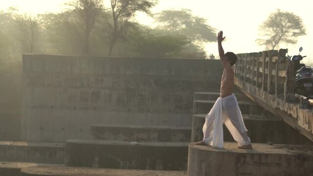Indian boy wearing dhoti praying to god. young hindu priest worshiping god in the morning.