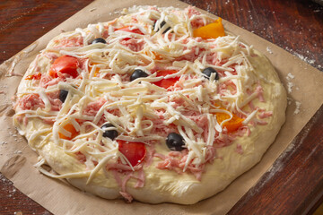 Cooking pizza with cheese and olives in domestic conditions. Delicious food with your own hands