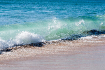 Surf waves crashing in on deserted beach at Tairua
