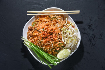 Pad Thai is delicious Thai food. Pat Thai in a plate placed on a black table. Thai noodles. 