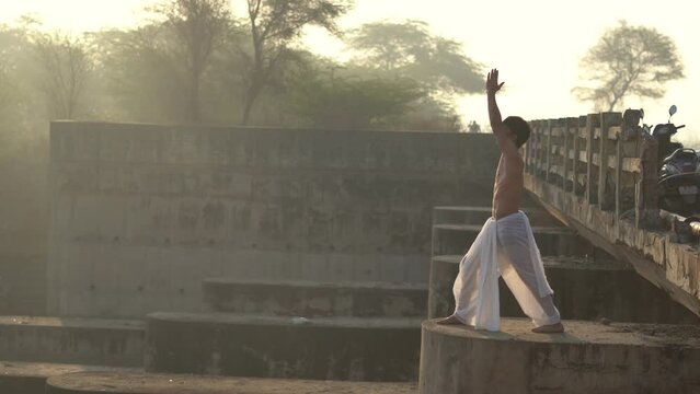 Indian boy wearing dhoti praying to god. young hindu priest worshiping god in the morning.