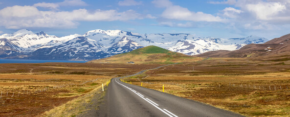 Snow covered mountains, meadows along scenic highway 1 in Iceland.