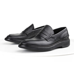 Black penny loafers on a white background
