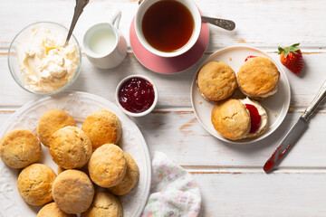 Traditional british scones with clotted cream and strawberry jam with a cup of tea