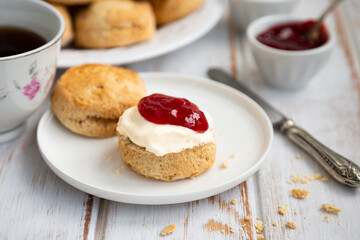 Tea time with delicious scones with clotted cream and strawberry jam