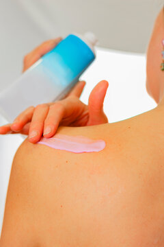 protección estacional de la piel. mujer aplicando crema hidratante en cuerpo.