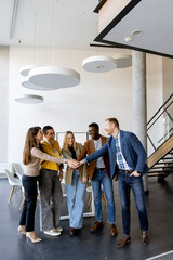 Group of positive businesspeople standing together in the office