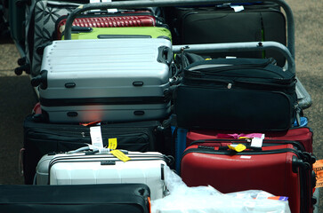 Airport ground support staff loading Luggage, suitcases and cargo into the aircraft hold on the airport apron. passenger jet. air travel. baggage handlers trolly is used to move bags 