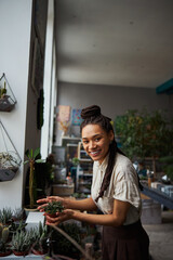 Florist with a mini succulent in her hands looking ahead