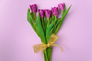 Bouquet of purple tulips on a blue solid background, top view