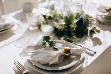 Elegant Place Setting with gold and white decoration in restaurant. Table set