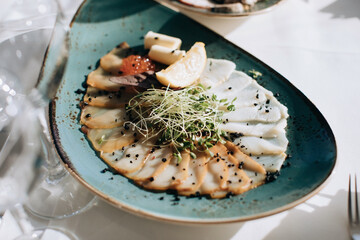 Different types of fish on a plate. Wedding table setting with food in restauran