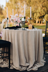 Outdoor wedding table set with flowers in boho style on lake beach