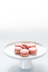 Amazing airy macarons on the shelves. White background. Selective focus. Copy space.