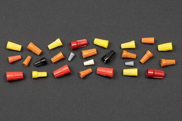 Horizontal flat layout of assorted color wire nuts on black background