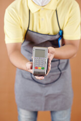 Cropped image of coffeeshop waiter giving credit card reader and accepting payment