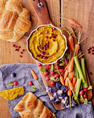 mesa posta de aperitivos, homus de grão de bico e cenoura com legumes.