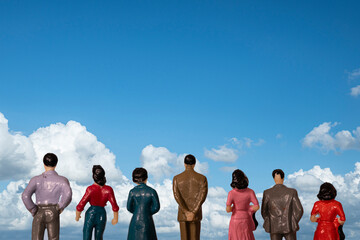 a couple of miniature people together on a colored surface	